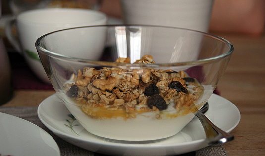 Frühstücksjoghurt mit Fruchtmus, Granola und Nüssen